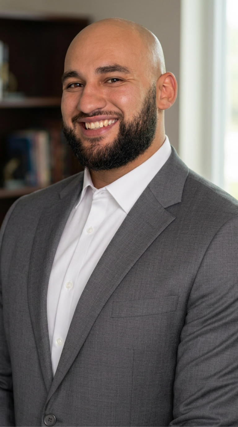 Richie Webber standing in office wearing white shirt and grey suit jacket